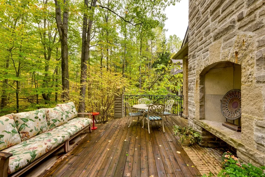 Freshly stained deck boards beside a stone fireplace wall